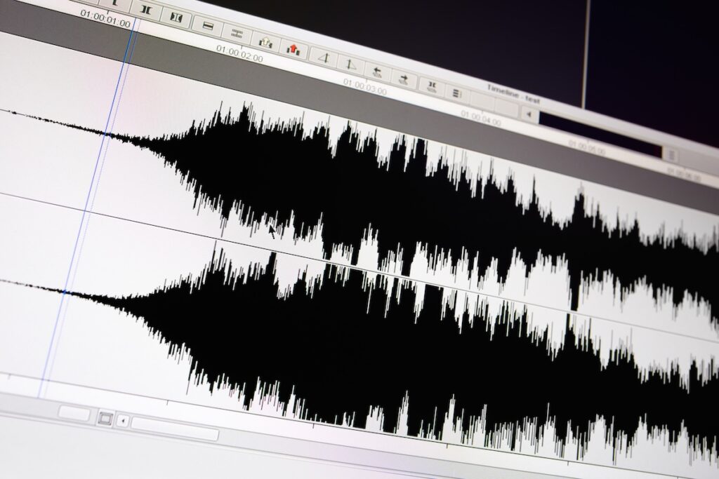 Timeline window with black sound waveform in audio production after audio compression is applied.